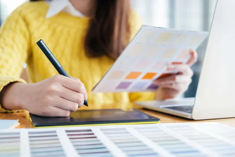 Cheap Web Design Liverpool 4 Graphic designer using a stylus tablet and color swatches for affordable website design services in Liverpool.