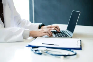 Healthcare professional using a laptop to review medical information, highlighting clear and user-friendly healthcare website design.